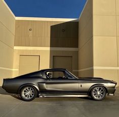 a car parked in front of a building with a blue sky behind it and the door open