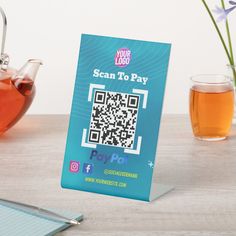 there is a tea pot next to a card with a qr code on it