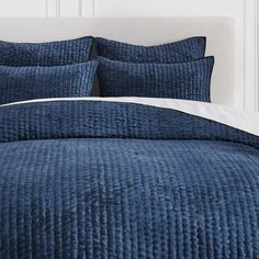 a bed with blue bedspread and pillows