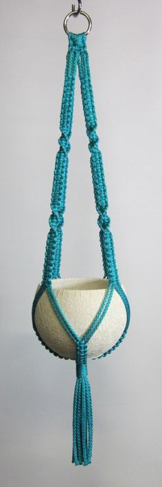 a blue beaded hanging planter with tassels