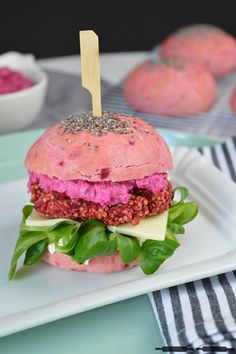 a sandwich on a plate with lettuce and other food items in the background