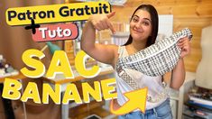 a woman holding up a scarf in front of a store sign that says sac banane