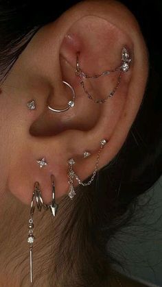 a woman's ear with several piercings attached to the side of her ear