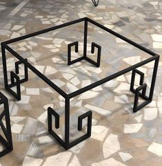 an unusual coffee table made out of metal and glass with geometric shapes on the top