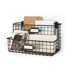 a wire basket with several items in it and labels on the front, along with two folders