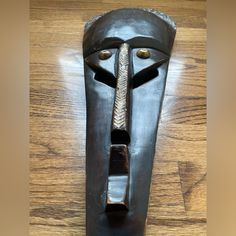 a wooden mask with a metal tie on it