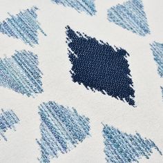 an up close shot of blue and white fabric with small dots on the back of it