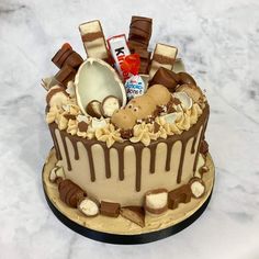 a cake decorated with chocolate, marshmallows and other candies on a marble surface