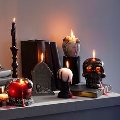 there are many candles that have been placed on the table with skulls and other decorations