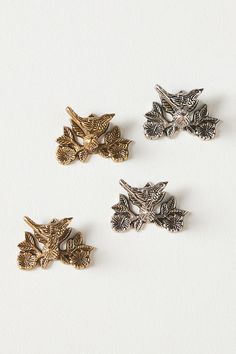 four different types of brooches on a white surface, one with an owl and the other with a bird