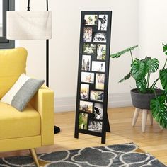 a living room with a yellow chair and a black framed photo stand in front of a window