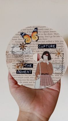 a person holding up a piece of paper with the words capture, the moment and butterflies on it