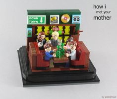 there is a lego model of people sitting at a table in front of a store