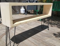 a wooden table with hairpin legs and a shelf on the top that is made out of plywood