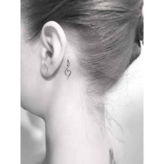 a woman's left ear has a small heart tattoo on the back of her right ear