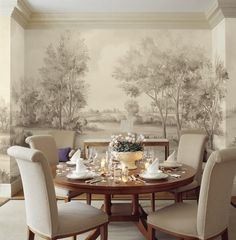 a dining room table with chairs around it and a wall mural on the wall behind it