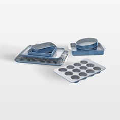 an assortment of kitchen items including muffin tins and cupcake pans on a white background