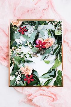 a card with flowers and greenery on it, surrounded by pink ruffles