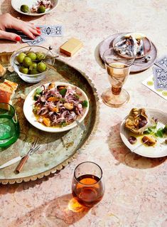 a table topped with plates and bowls filled with different types of food next to drinks