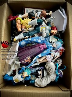 an open cardboard box filled with anime figurines