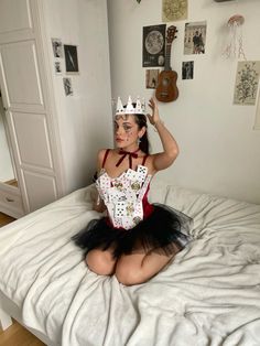 a woman sitting on top of a bed wearing a costume