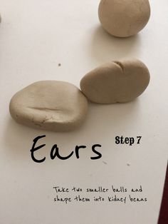 three rocks sitting on top of a piece of paper with the words ears written below them