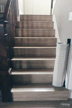 there is a roll of toilet paper on the bottom of this stair case next to an open door