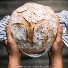 a person holding a loaf of bread in their hands