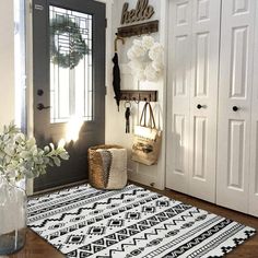 a black and white area rug in front of a door with some flowers on it