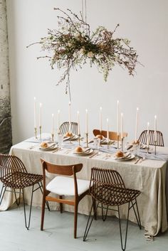 the table is set with candles, plates and napkins for an elegant dinner party