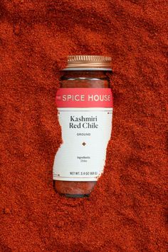 the spice house kashmik red chilli is in a glass jar on a red carpet