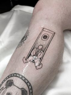 a man's leg with a tattoo on it that has an image of a dog and a door