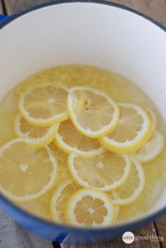 a pot filled with lemon slices on top of a wooden table