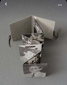 an open book with pictures inside on a gray surface