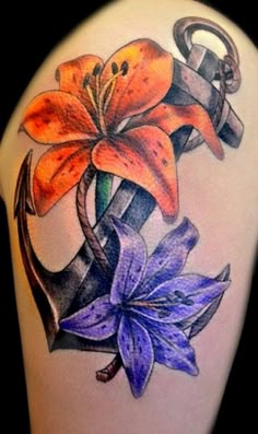 a tattoo with an anchor and flowers on it