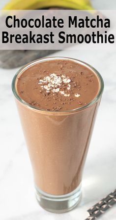 chocolate matcha breakfast smoothie in a tall glass on a marble table with bananas