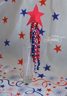 red, white and blue paper straws in a glass vase on a patriotic tablecloth