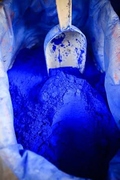 a bucket filled with blue powder sitting on top of a table