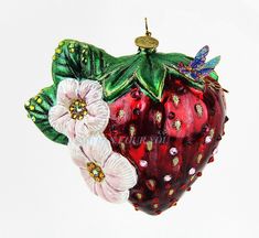 an ornament shaped like a strawberry with leaves and flowers hanging from it's side