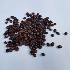 a pile of coffee beans sitting on top of a white table