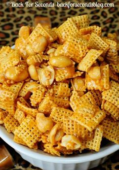 a bowl filled with cheetos sitting on top of a table next to crackers