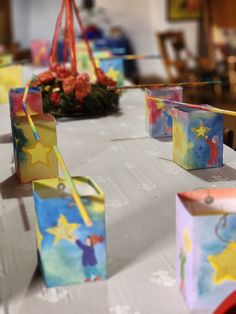 small gift bags are sitting on a table with streamers in the air above them