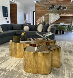 a living room filled with furniture next to a stair case on top of a carpeted floor