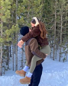 a man carrying a woman on his back in the snow