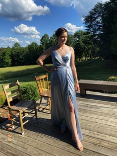 a woman standing on a wooden deck wearing a dress