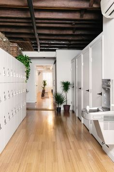 an office with white lockers and wooden flooring is pictured in this image from the hallway