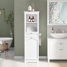 a bathroom with green walls and white furniture in the corner, along with a bathtub