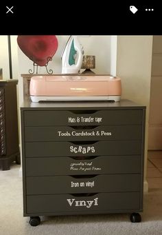 a black dresser with writing on it and a pink ironing board next to it