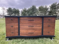 a large wooden dresser sitting in the grass