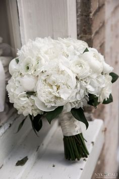 a bouquet of white flowers sitting on top of a window sill